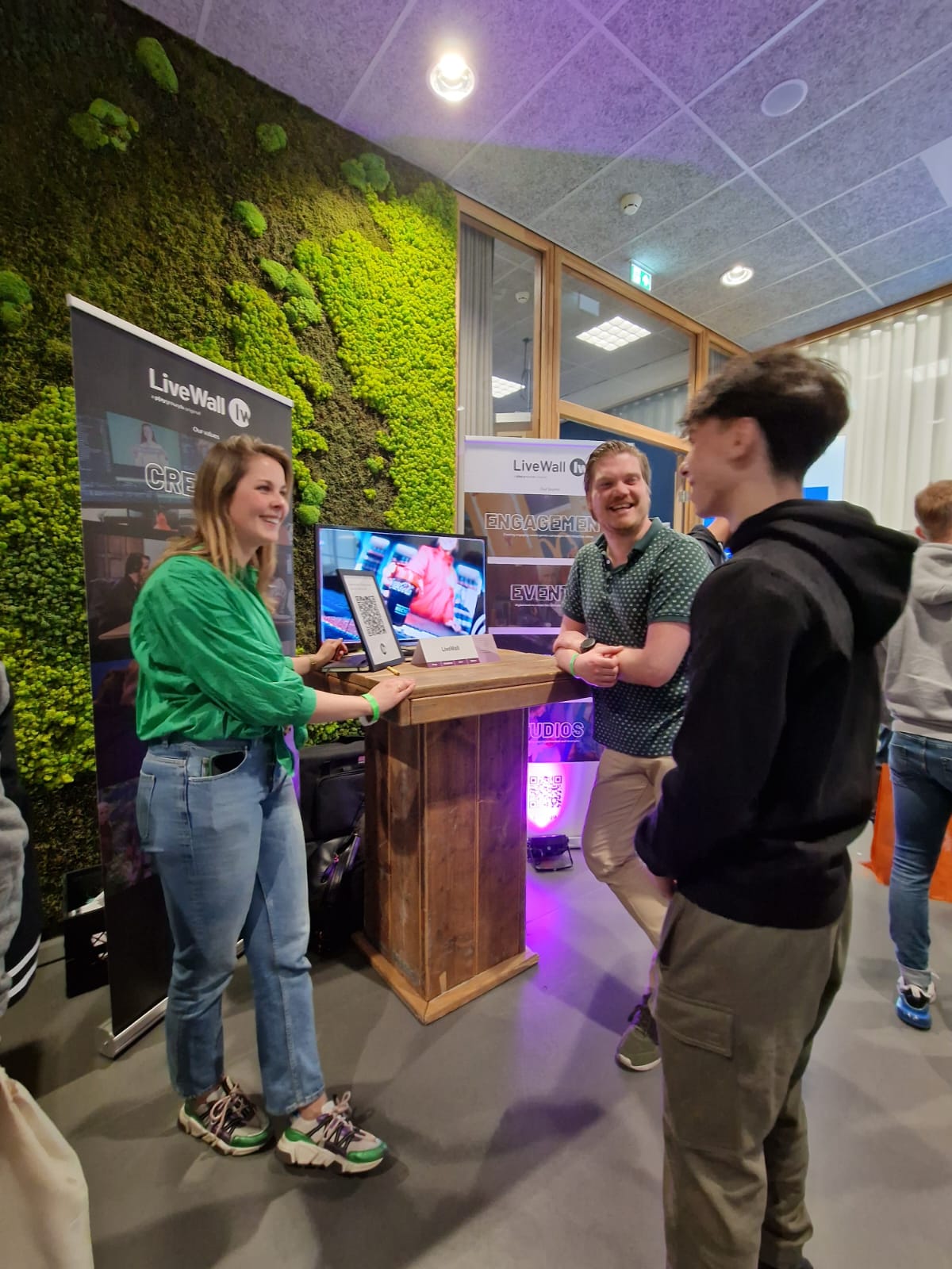Bezoekers bij de livewall-stand op Fontys doen mee met PresentersWall via een QR-code