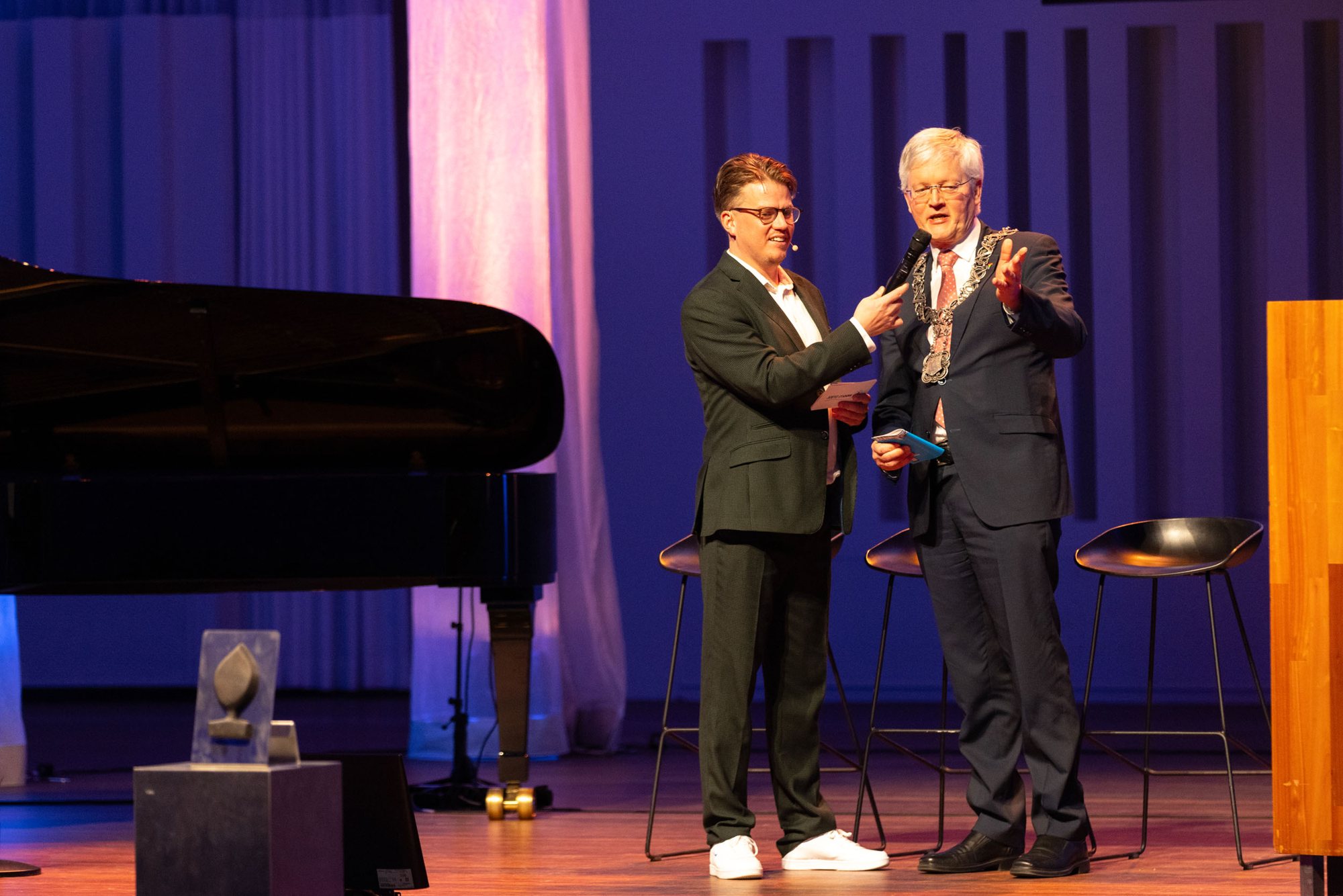 Jerre Maas interviewt een gast op het podium van een prijsuitreiking